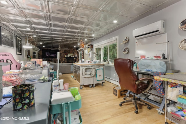 home office with baseboard heating, a wall mounted air conditioner, and hardwood / wood-style flooring