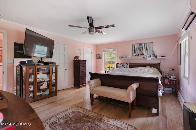 bedroom featuring ceiling fan, light wood-type flooring, and a wall mounted AC