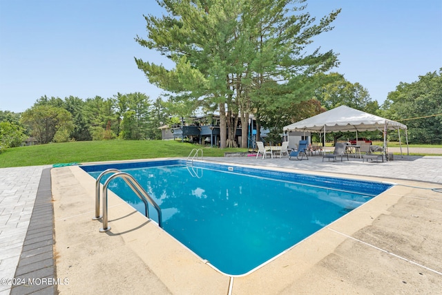 view of swimming pool featuring a patio area and a yard