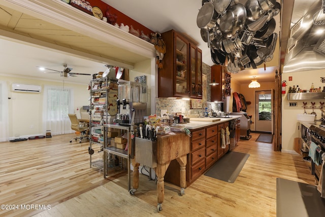 kitchen with ceiling fan, light wood-type flooring, backsplash, and an AC wall unit