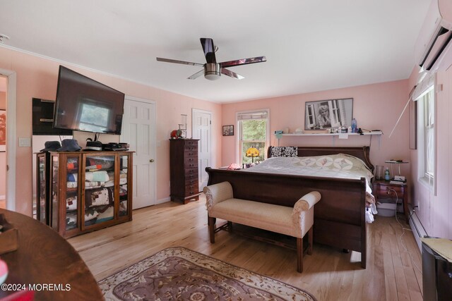 bedroom featuring a wall mounted AC, light hardwood / wood-style flooring, and ceiling fan