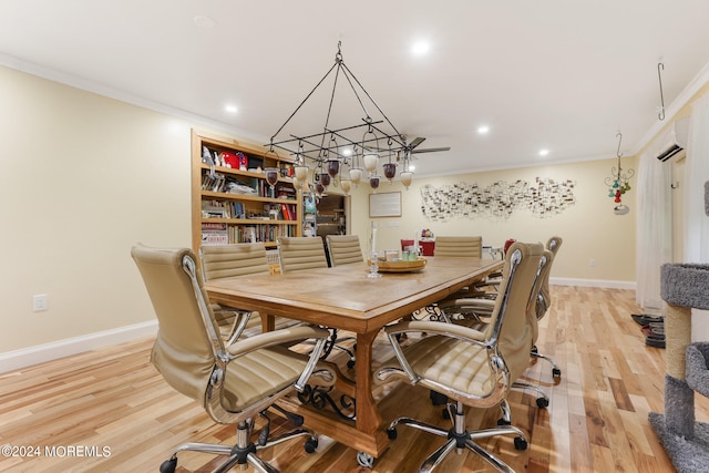 dining space featuring light hardwood / wood-style floors, a wall mounted air conditioner, and ornamental molding