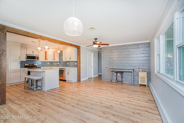 10 Inverell Dr, Toms River, NJ 08757 - kitchen with stainless steel appliances, a ceiling fan, crown molding, a breakfast bar area, and light countertops