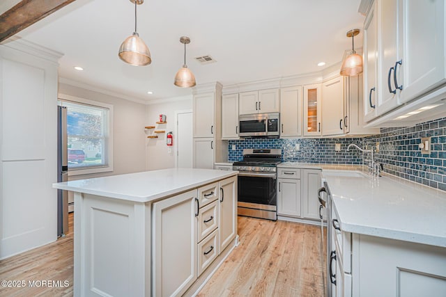 10 Inverell Dr, Toms River, NJ 08757 - kitchen with stainless steel appliances, light wood-style floors, a sink, crown molding, and decorative backsplash