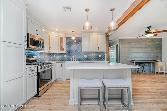 10 Inverell Dr, Toms River, NJ 08757 - kitchen with appliances with stainless steel finishes, light wood-style flooring, backsplash, light countertops, and ornamental molding