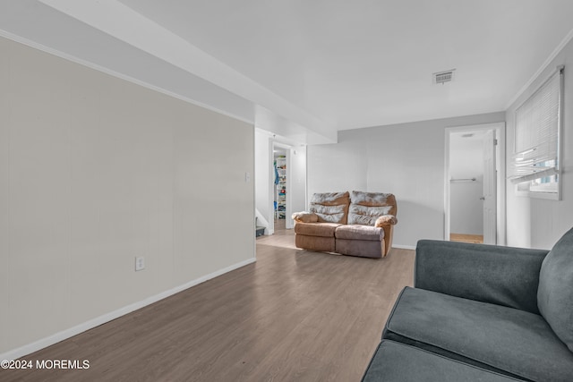 living room featuring hardwood / wood-style floors and crown molding