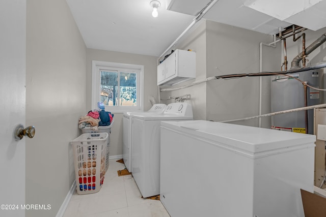 laundry area featuring washing machine and dryer, light tile patterned floors, and cabinets