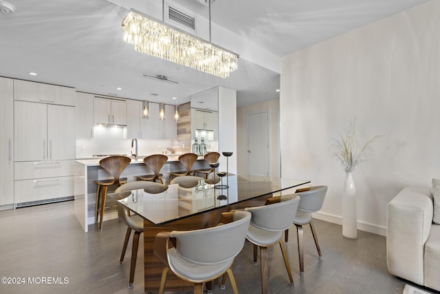 dining area featuring a notable chandelier, light wood-type flooring, and sink