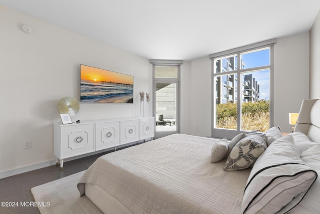 bedroom with multiple windows and dark hardwood / wood-style flooring