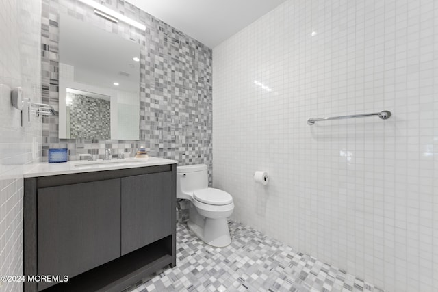 bathroom featuring tile patterned floors, backsplash, vanity, and tile walls