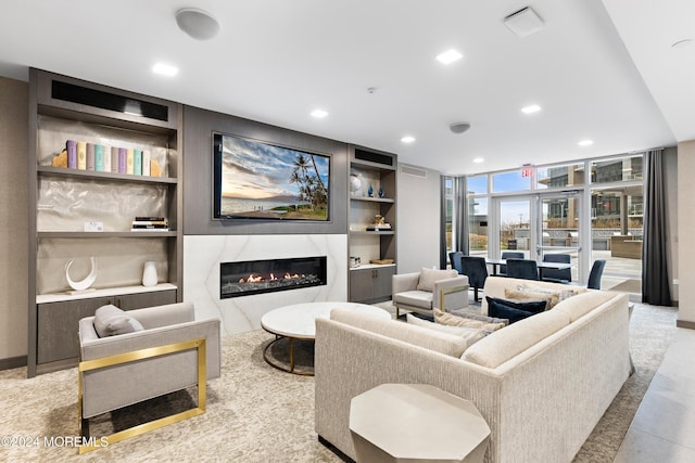 living room featuring floor to ceiling windows, built in features, and a high end fireplace