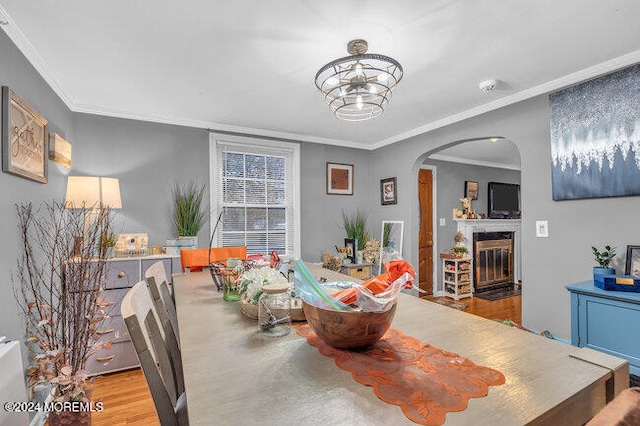 dining area with light wood-type flooring and crown molding