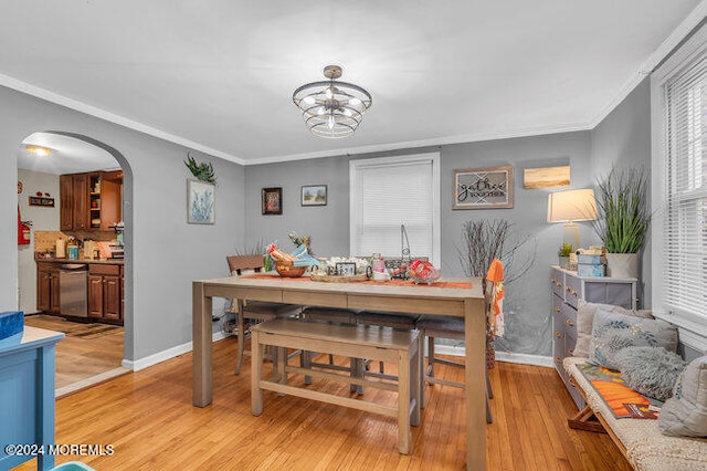 dining room featuring light wood-type flooring and crown molding