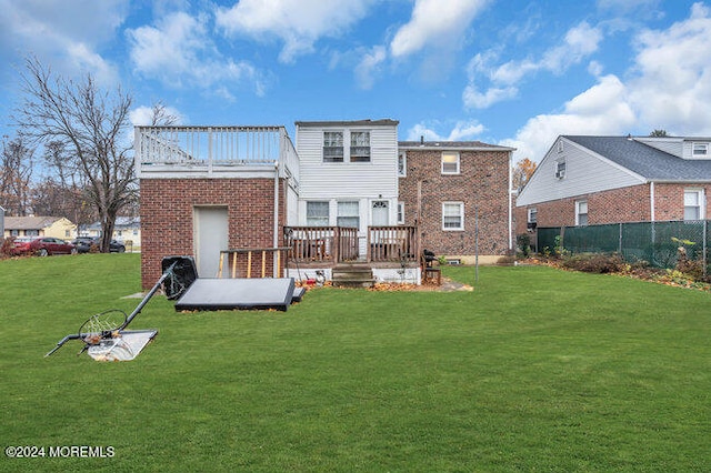 rear view of property with a lawn and a wooden deck