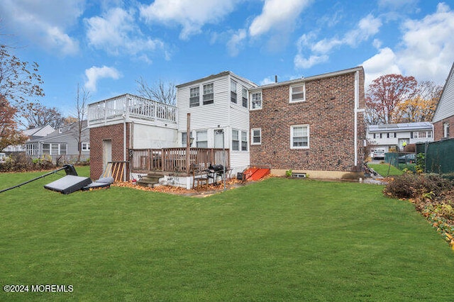 rear view of house with a lawn and a deck