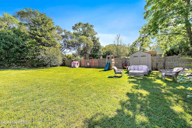 view of yard with a playground and a storage unit