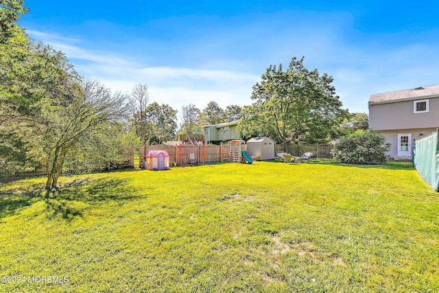 view of yard with a playground and a storage shed