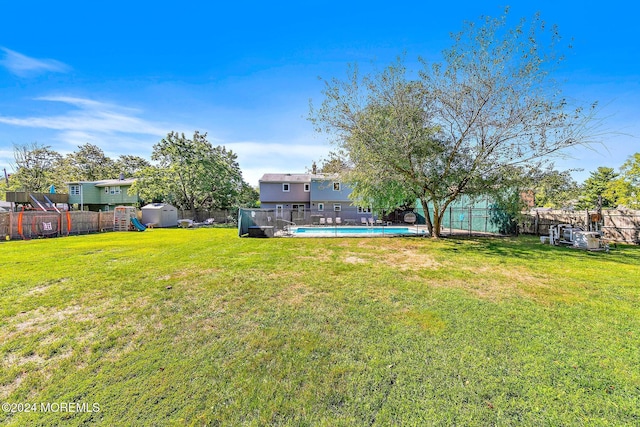 view of yard with a fenced in pool and a shed