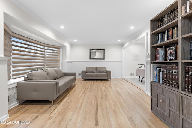 living room with light hardwood / wood-style flooring and ornamental molding