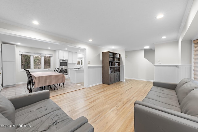 living room with light hardwood / wood-style floors and ornamental molding