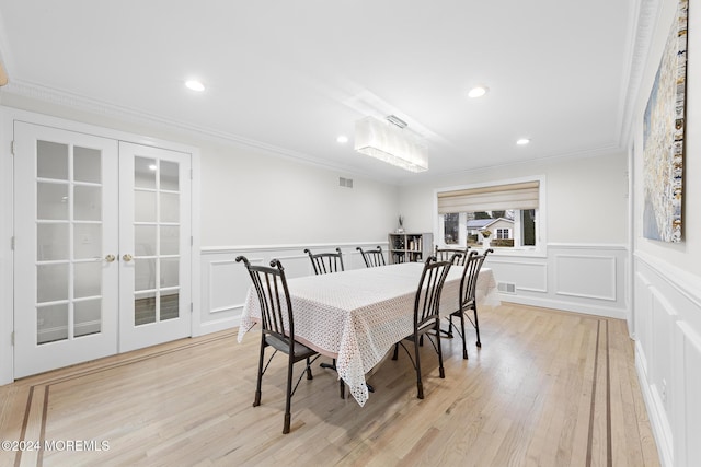 dining room with ornamental molding, french doors, and light hardwood / wood-style flooring