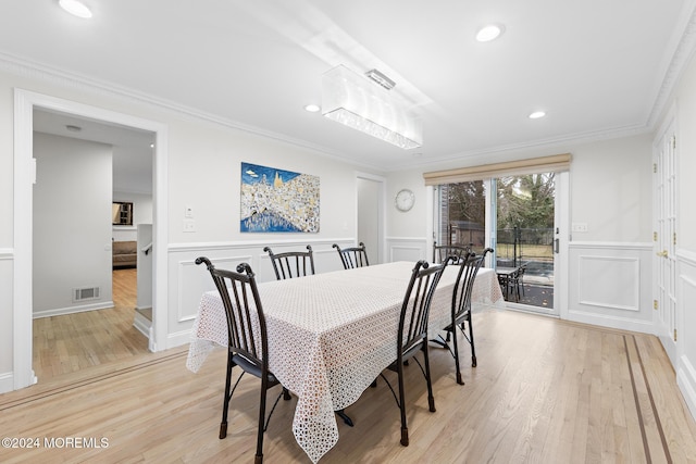 dining area with light hardwood / wood-style flooring and crown molding