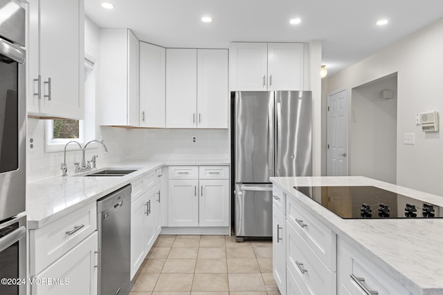 kitchen with white cabinets, light tile patterned flooring, sink, and appliances with stainless steel finishes