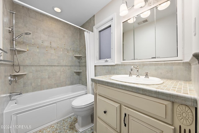 full bathroom with vanity, tile patterned floors, toilet, tile walls, and shower / tub combo with curtain