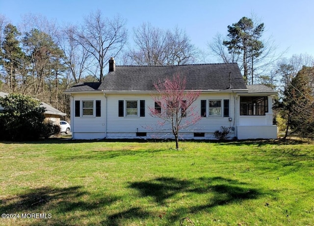 rear view of house featuring a lawn