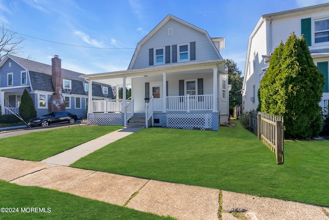 dutch colonial with a gambrel roof, a porch, a front lawn, and fence