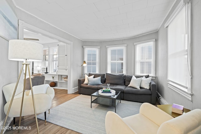 living room featuring cooling unit, baseboards, plenty of natural light, and wood finished floors