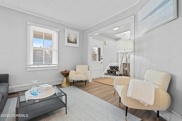 living area featuring a baseboard heating unit and wood finished floors