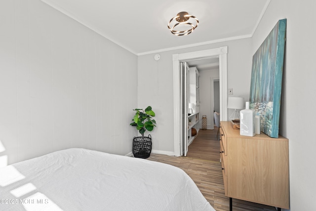 bedroom featuring wood finished floors, baseboards, and ornamental molding