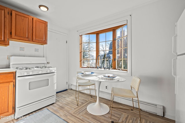 kitchen with light countertops, decorative backsplash, light wood-style floors, white appliances, and a baseboard radiator