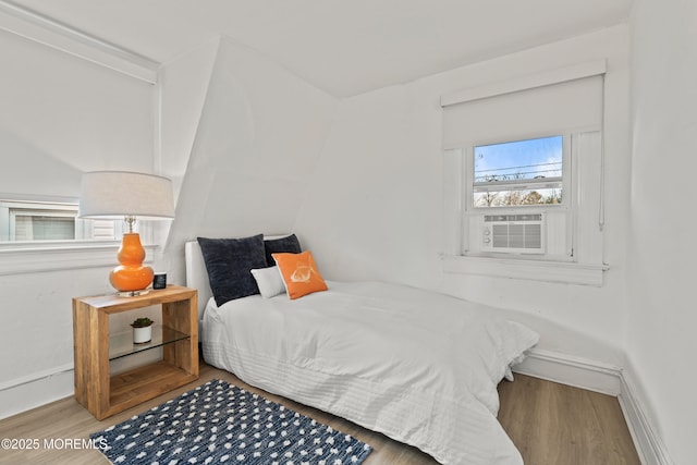 bedroom with baseboards and wood finished floors