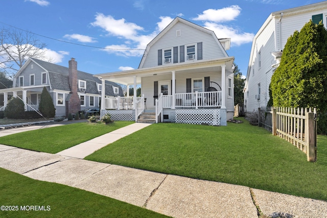 dutch colonial with a front yard, fence, covered porch, and a gambrel roof