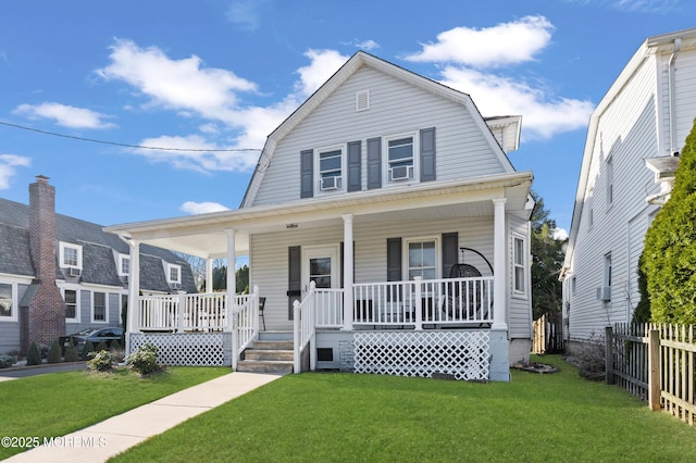 dutch colonial with covered porch, a gambrel roof, a front yard, and fence