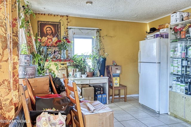 kitchen with white fridge, light tile patterned flooring, and a textured ceiling