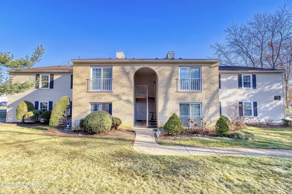 view of front of property featuring central AC unit and a front yard