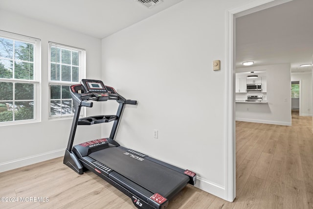 workout area with light hardwood / wood-style flooring