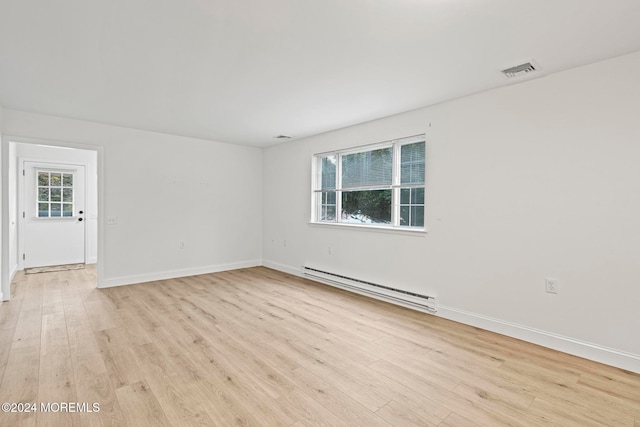 empty room with a baseboard radiator, light hardwood / wood-style flooring, and a wealth of natural light