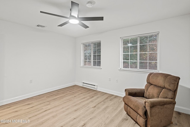 living area featuring ceiling fan, light hardwood / wood-style floors, and a baseboard radiator