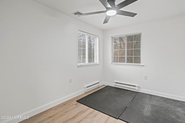 unfurnished room featuring hardwood / wood-style flooring, ceiling fan, and baseboard heating