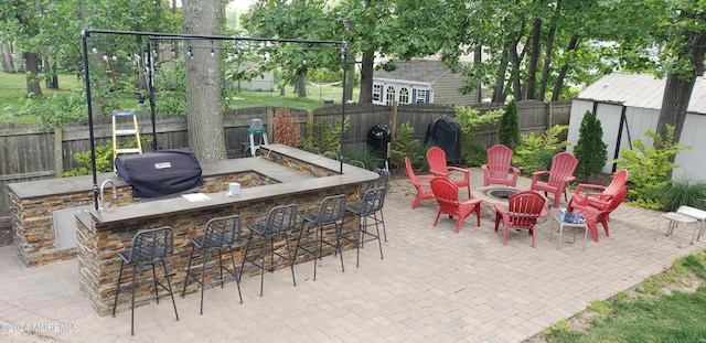 view of patio / terrace featuring a grill, exterior bar, and an outdoor fire pit