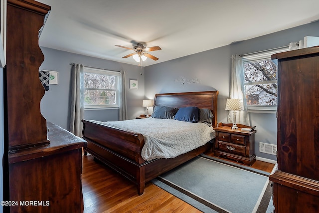 bedroom with dark hardwood / wood-style flooring and ceiling fan