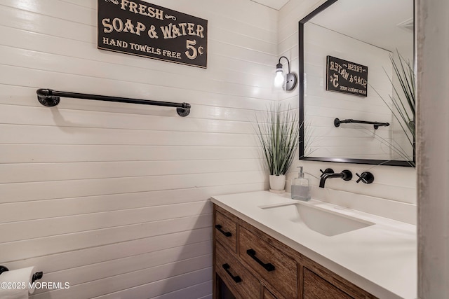 bathroom with wooden walls and vanity