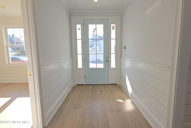 entryway with crown molding and light hardwood / wood-style flooring