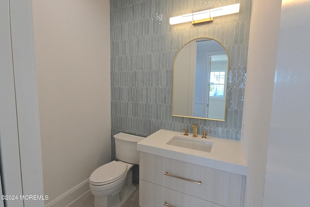 bathroom with tasteful backsplash, vanity, and toilet