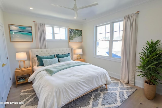 bedroom featuring hardwood / wood-style floors, ceiling fan, and crown molding