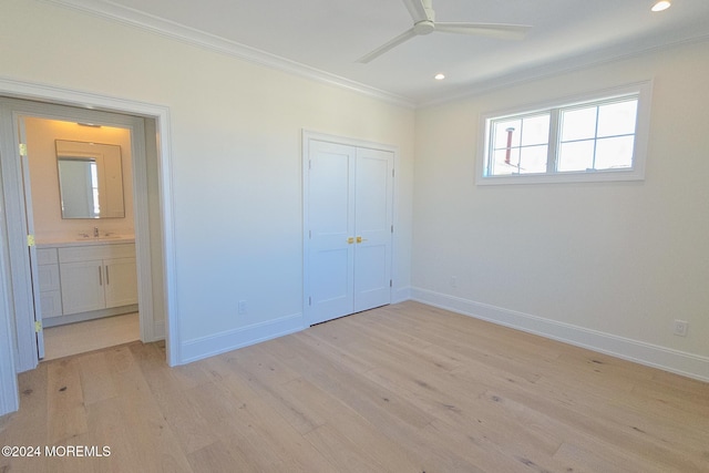 unfurnished bedroom featuring ceiling fan, sink, light wood-type flooring, a closet, and ornamental molding